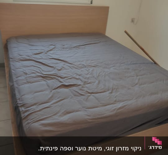 מיטה עם מצעים אפורים בחדר שינה